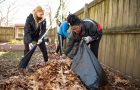Senior Shaniece Cole, right, and sophomore Nikki Zavondy, left, work to rake and bag leaves from the playgrounds at Hope House.