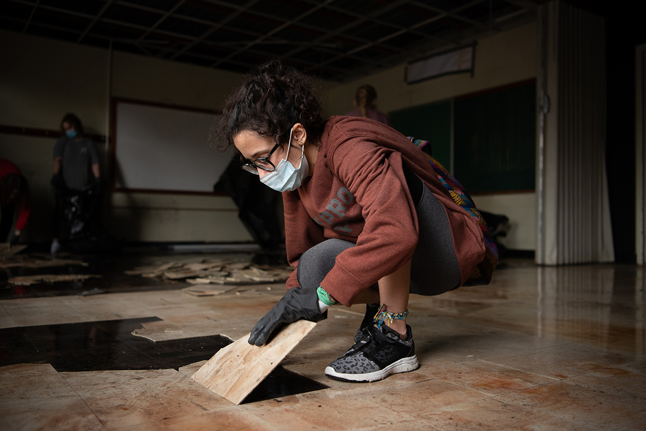 Joie Pecoraro removes floor tiles from a second story classroom of a church that will soon become a community center.