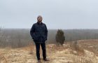 Dr. Keith Pluymers standing in a field