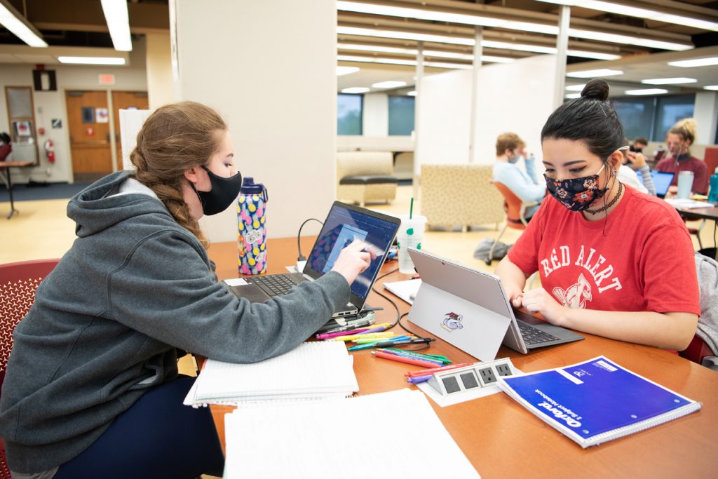 Photograph of two students working at computers at a table on Milner Library's third floor