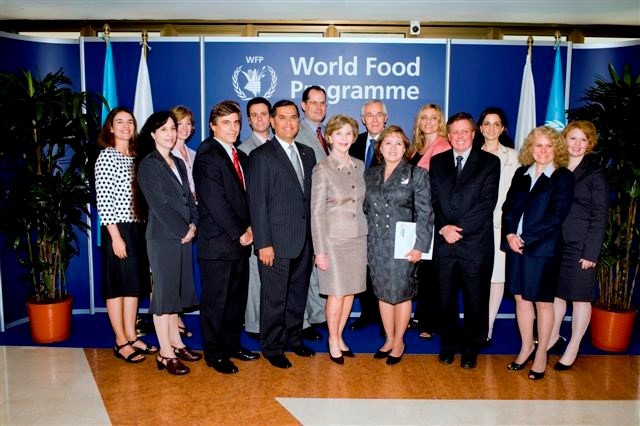 People standing and smiling in front of the World Food Programme Sign