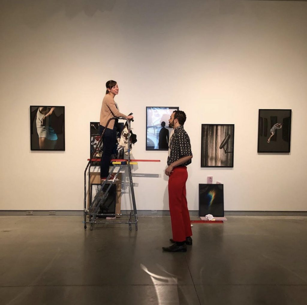 Kendra Paitz and student Sheldon Gooch installing artist exhibition at University Galleries
