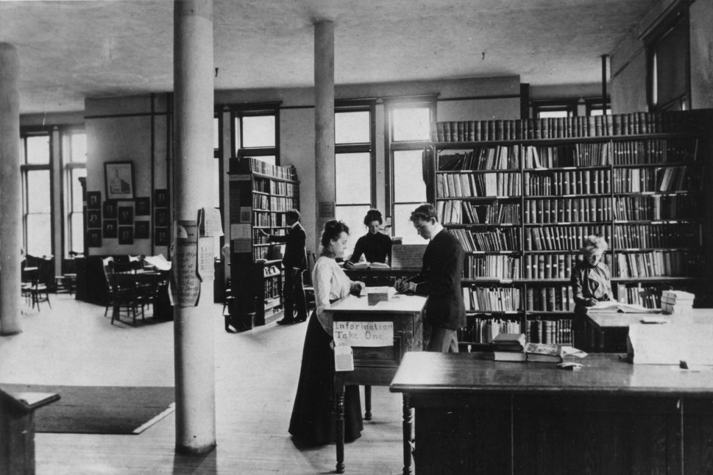 A black and white vintage photo of students in a library.