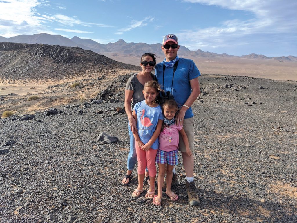 Jeff Williams standing with his wife and two kids in front of a mountain range.