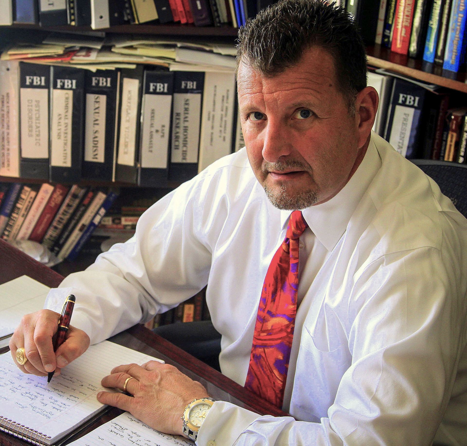 Mark Safarik at his desk with pen in hand