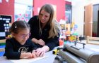 ISU graduate student helping young student in classroom