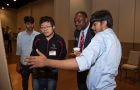 Dr. Aondover Tarhule, ice president for Academic Affairs and provost at Illinois State (second, right), meets with students presenting at the 2022 University Research Symposium.