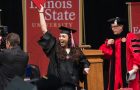 student at Commencement waving diploma