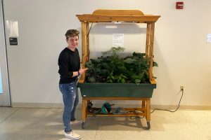 Student standing next to rolling garden