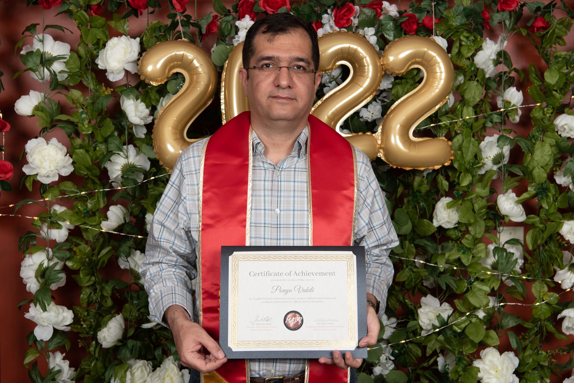 A student posing with their diploma.