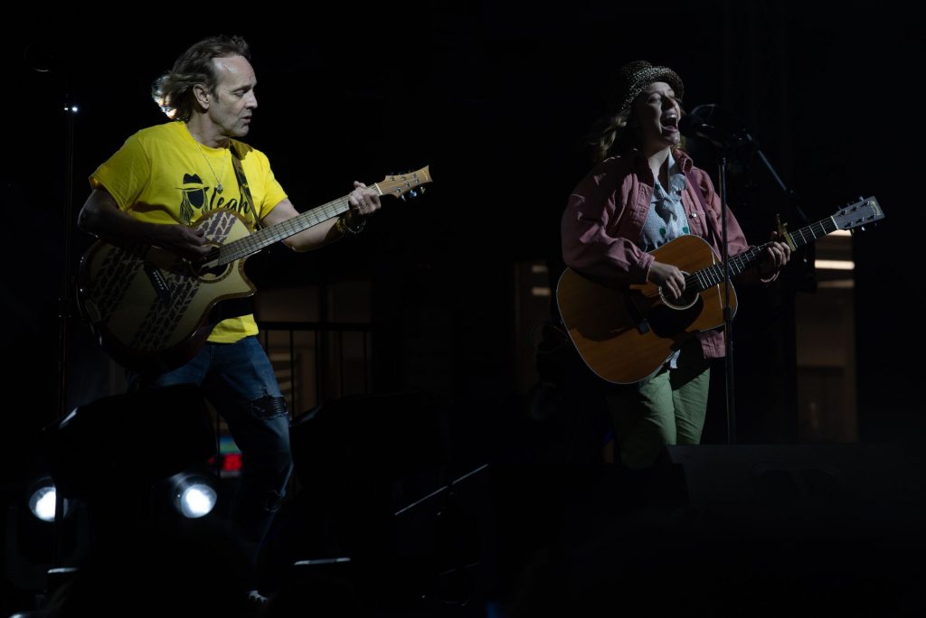 man and woman playing guitar on stage