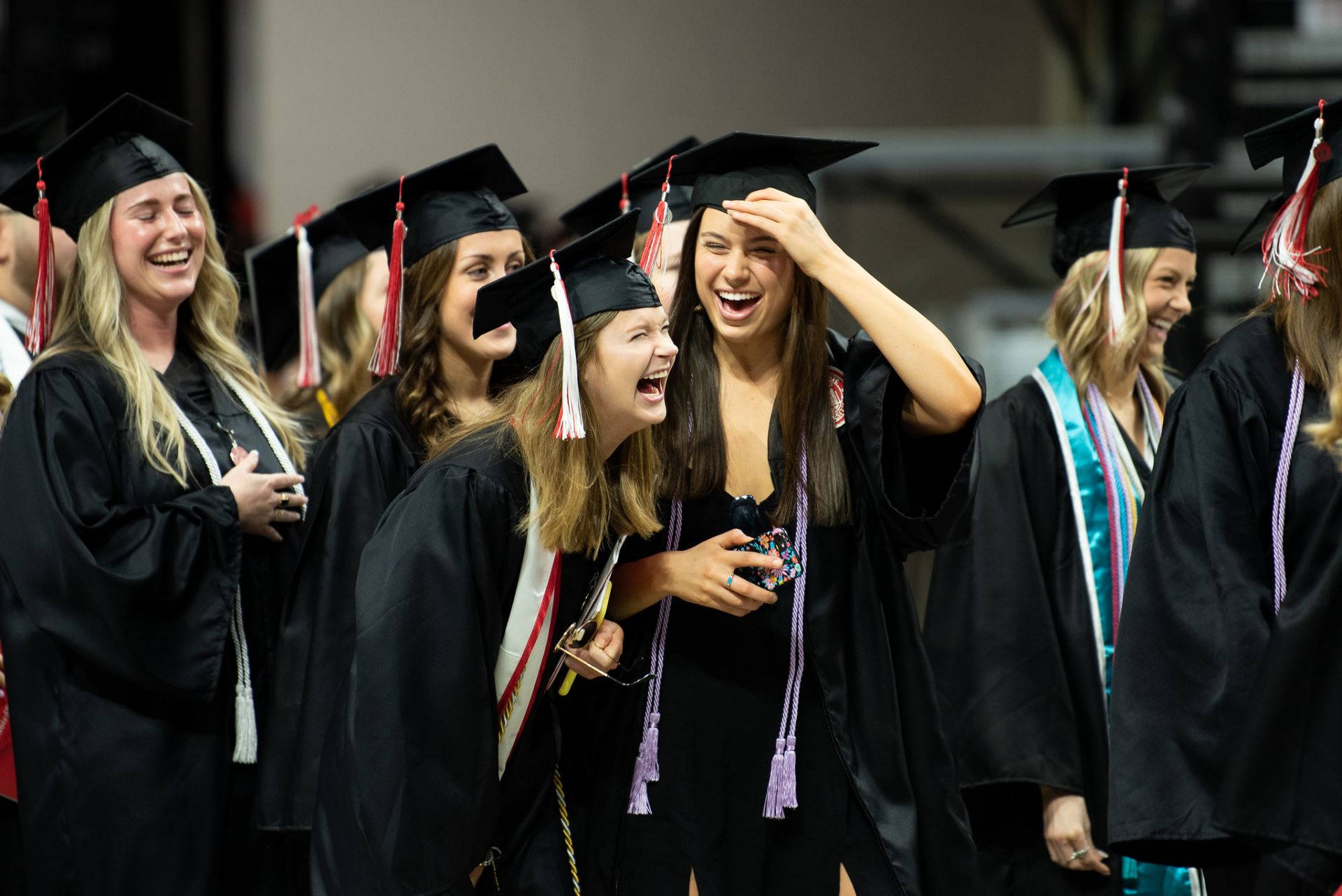 Graduates laughing while walking to their seats.