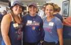 three women smiling and wearing Cubs shirts