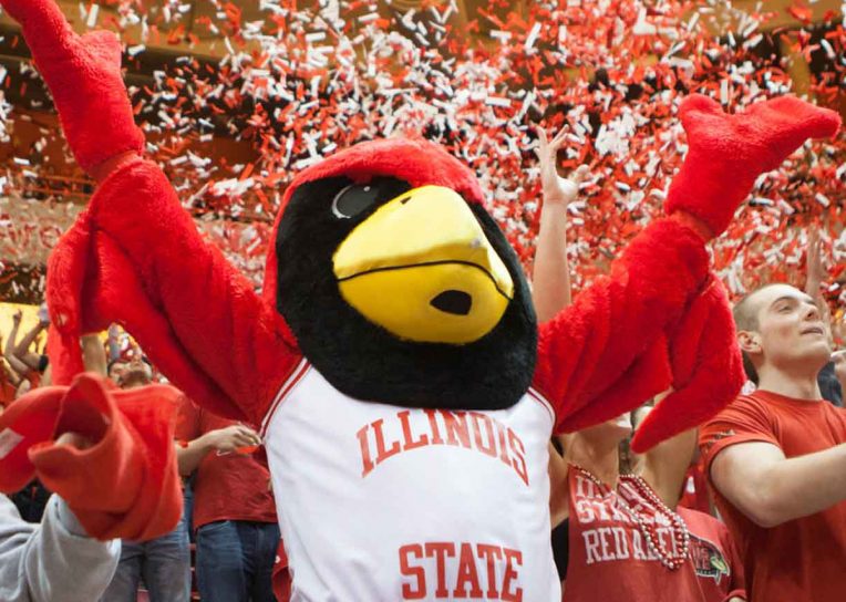 Reggie Redbird cheering Redbird success with confetti in the background