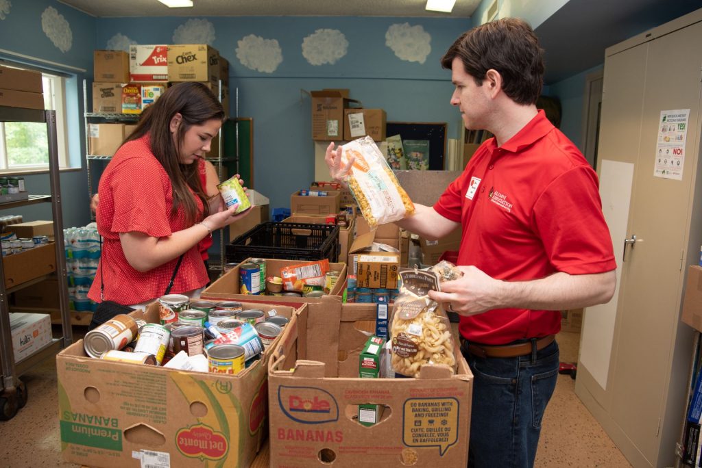 A woman and a man sort packaged food.