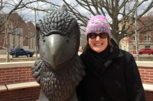 Trudy Gross stands by Redbird statue