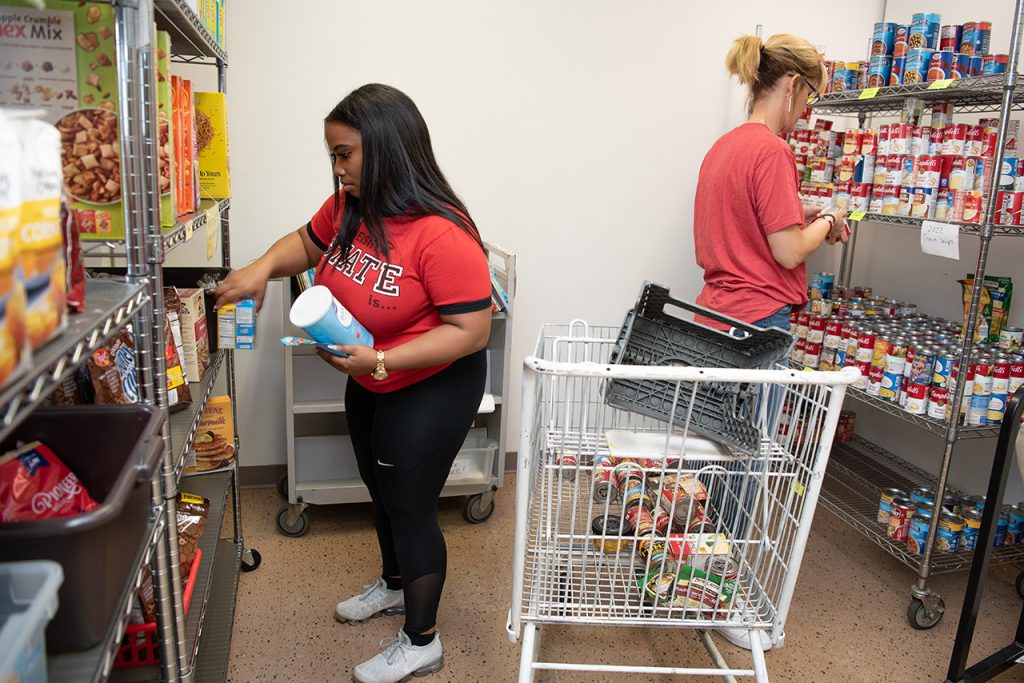two women sorting canned food