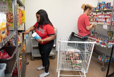 two women sorting canned food