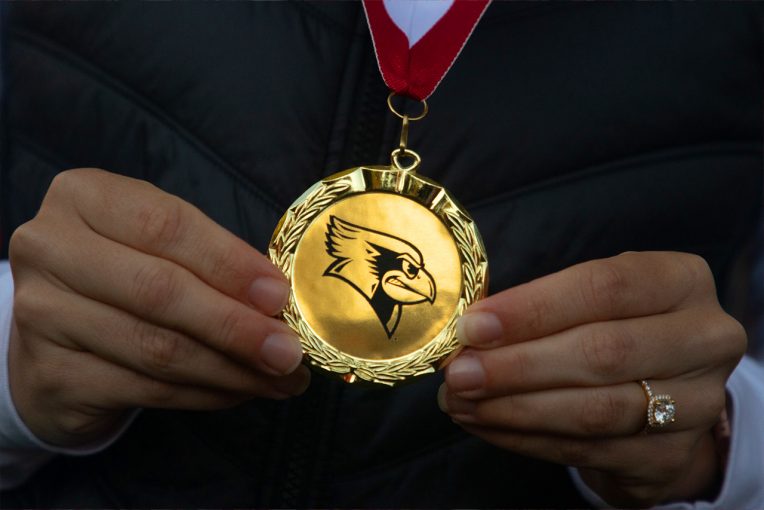 hands holding medal