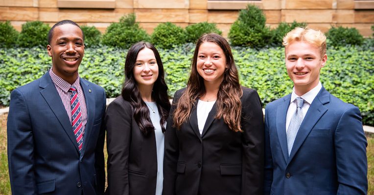 four students in business suits
