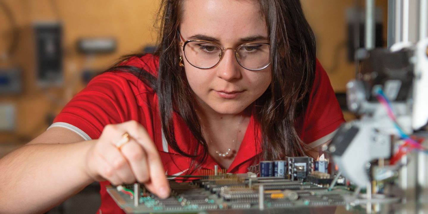 Summer 2022 alumni magazine cover showing student looking at circuits in a lab