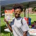 Student poses with a Welcome Week brochure