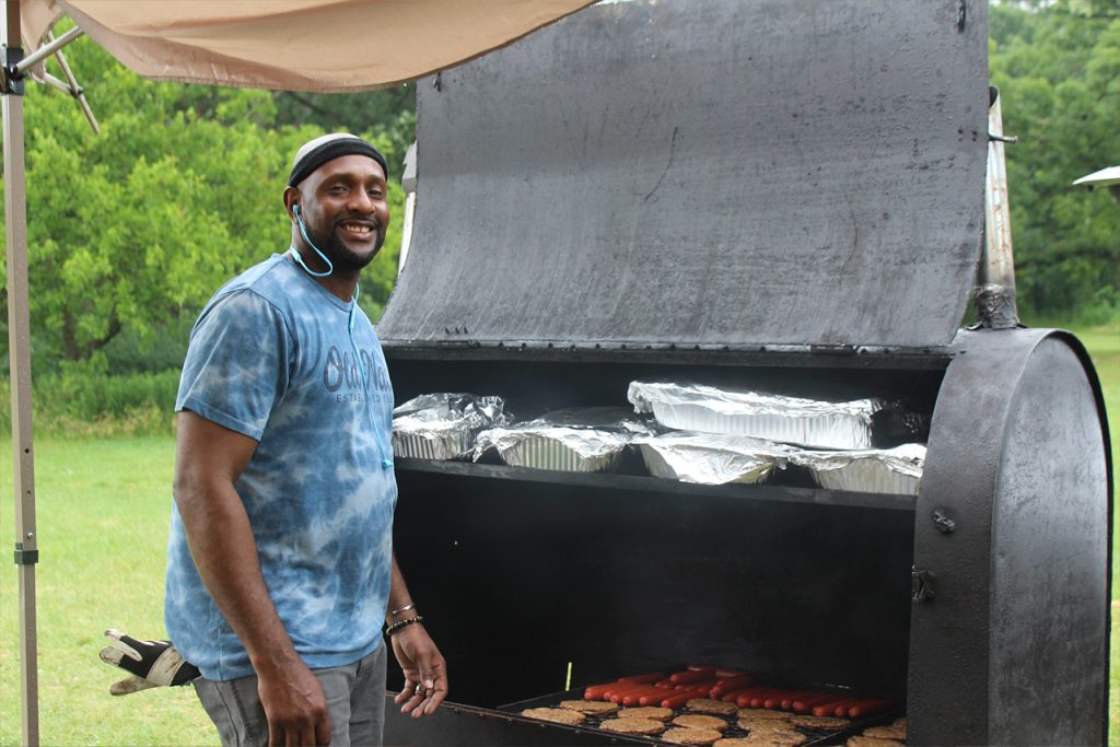 man standing at large grill