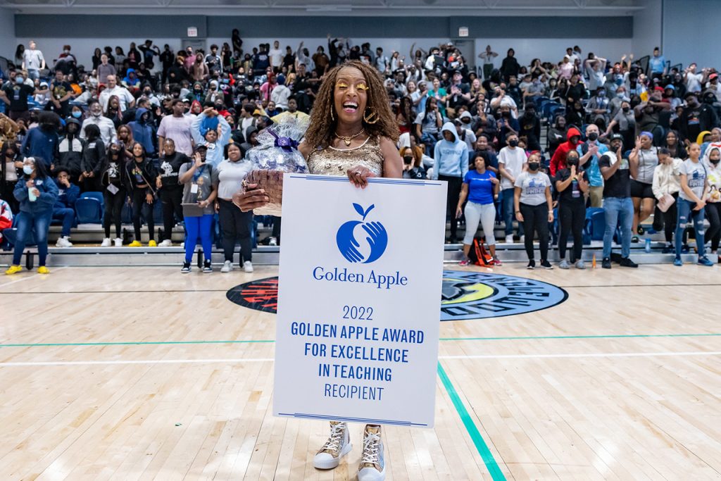 woman smiling while holding award banner