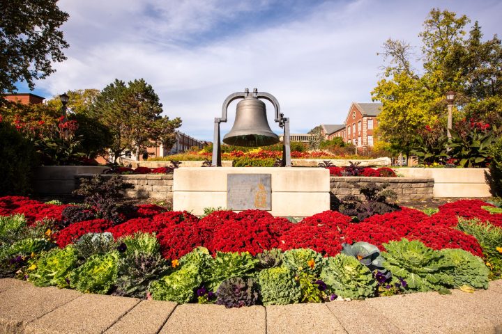 bell on the Quad, surrounded by red flowers