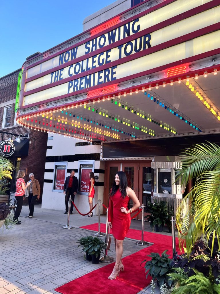 A student standing on the red carpet in front of Normal Theater.