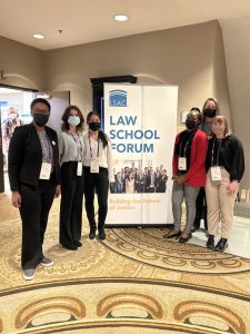 Six ISU students around a sign advertising the Law School Forum
