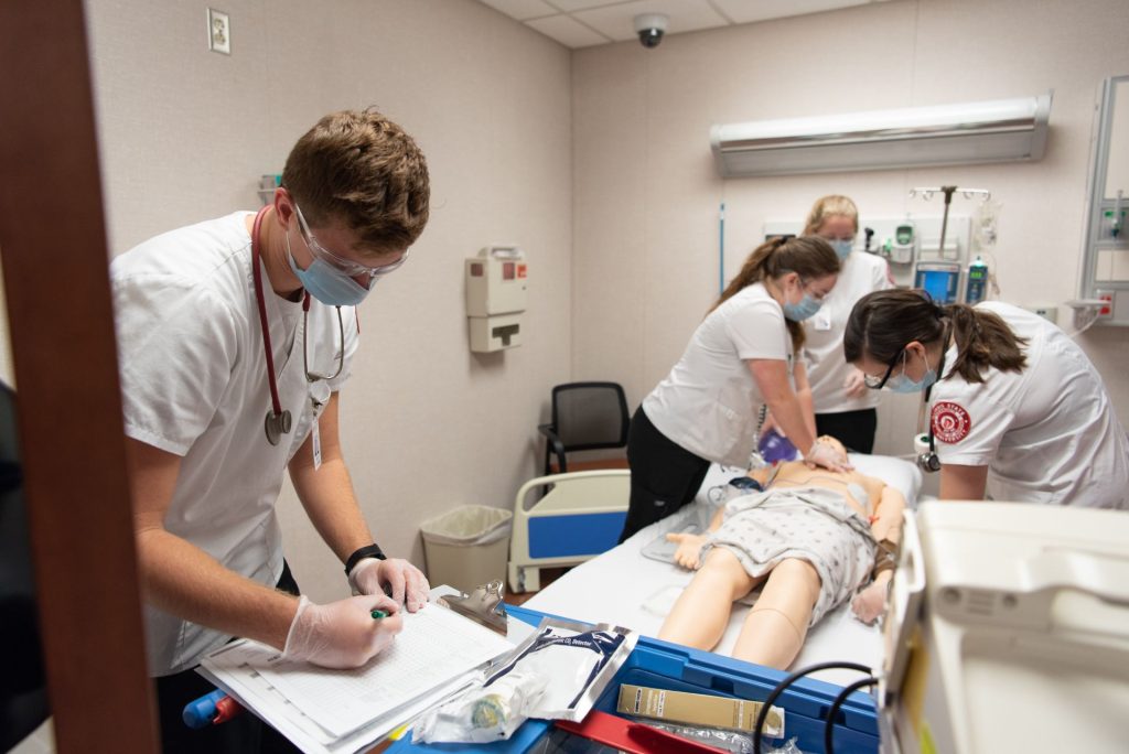 Students work with a manikin in the MCN nursing simulation lab