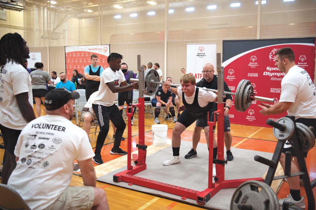 photo of Special Olympian weight lifter spotted by Redbird football players