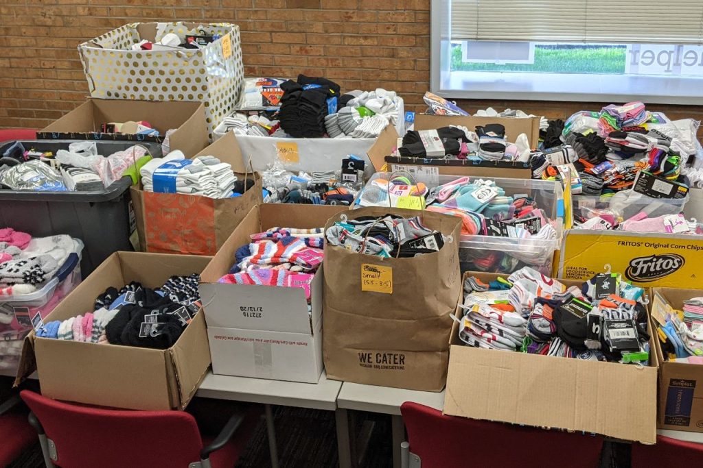More than twenty boxes filled with socks sit on a table in the Center for Civic Engagement