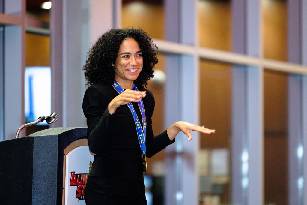 Lauren Ridloff on a stage speaking to a crowd using American Sign Language