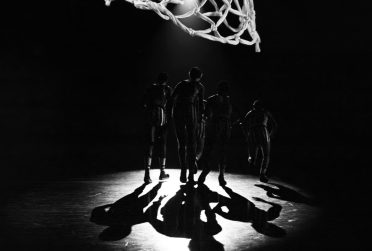 U.S. basketball players on a basketball court with net in foreground in silhouette Winter February 2012 State magazine cover
