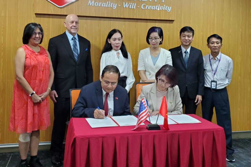 Group watching two people sign a document