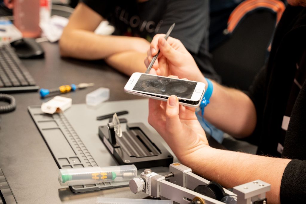A close-up of a TechZone associate working to open up an iPhone for repair