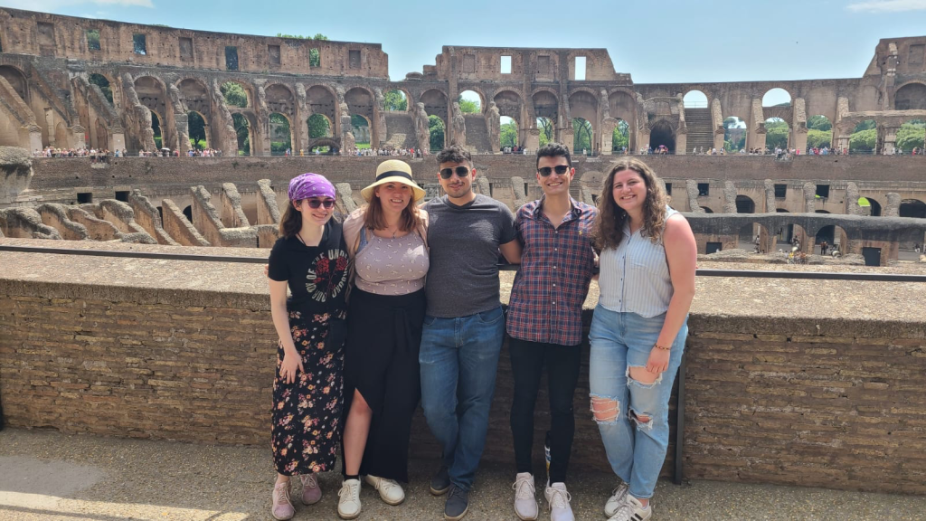 Brooke Lindell with four people visiting the Colosseum in Rome.