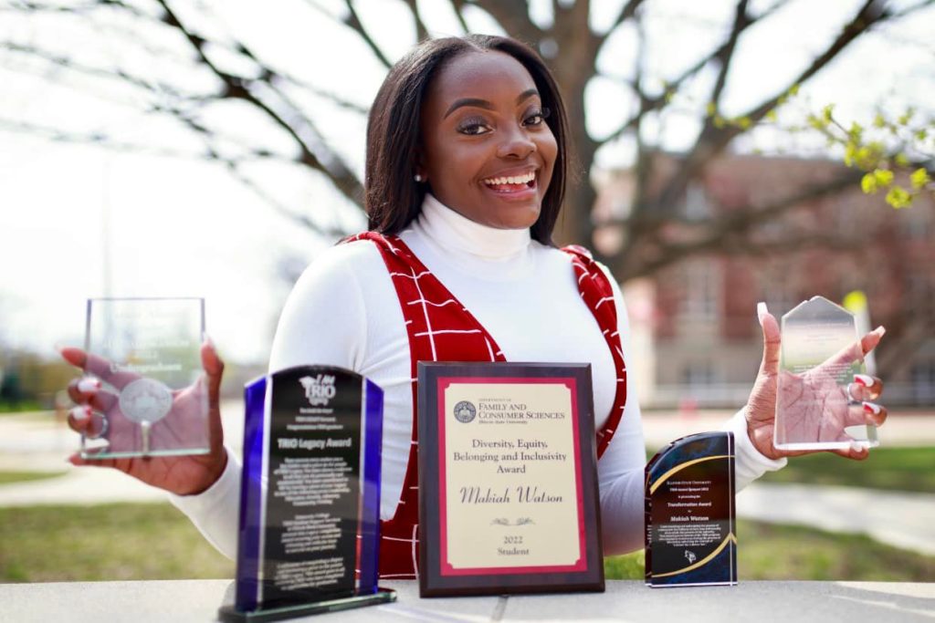 Makiah Watson posing with five awards earned at Illinois State