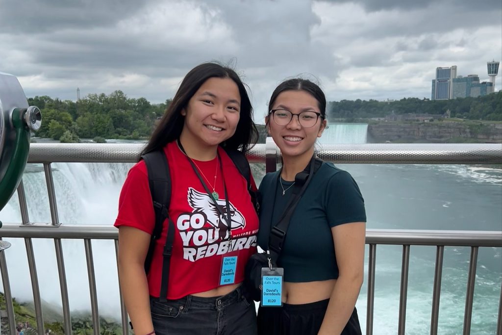 Two sisters standing together in front of Niagara Falls