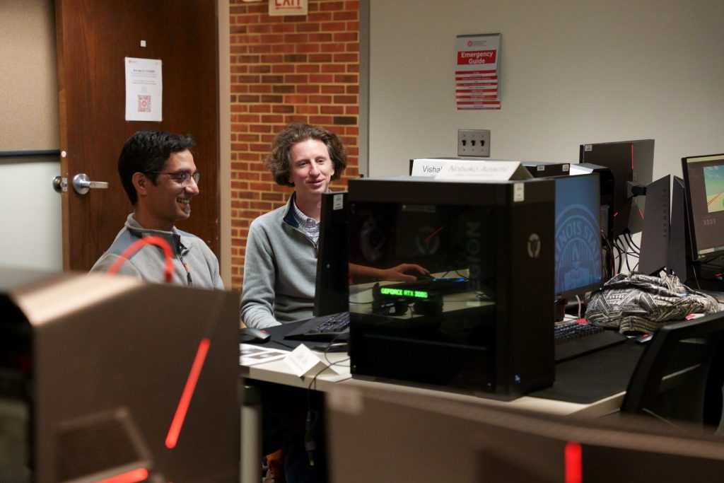 Two individuals work in a computer lab