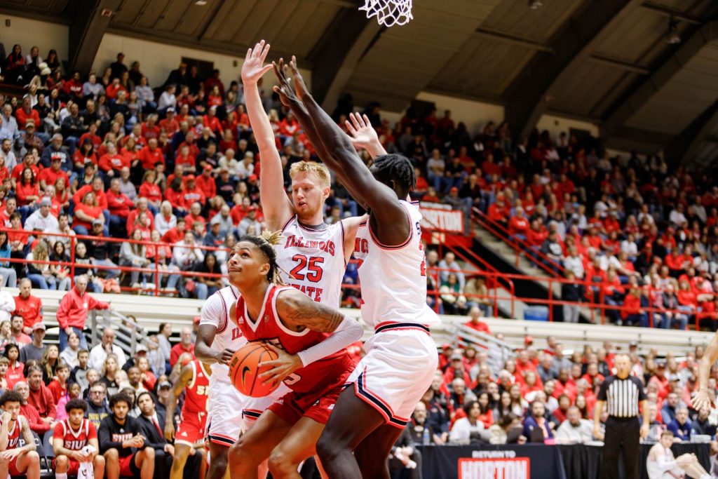 Two Illinois State men's basketball players defend an SIUE player with the ball