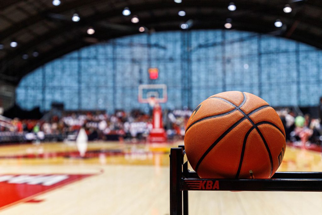 a basketball in the foreground with Horton Field House's arched, glass wall in the background