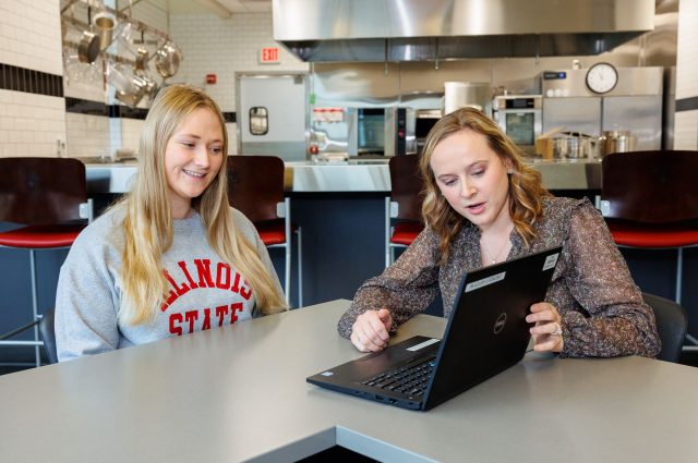 Student Gabby Stopka and Registered Dietitian Morgan Harm look at a computer screen as they plan meals for the week.