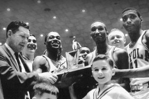 People smiling and holding a trophy