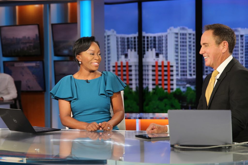 Daralene Jones interacting with a co-anchor at a news desk