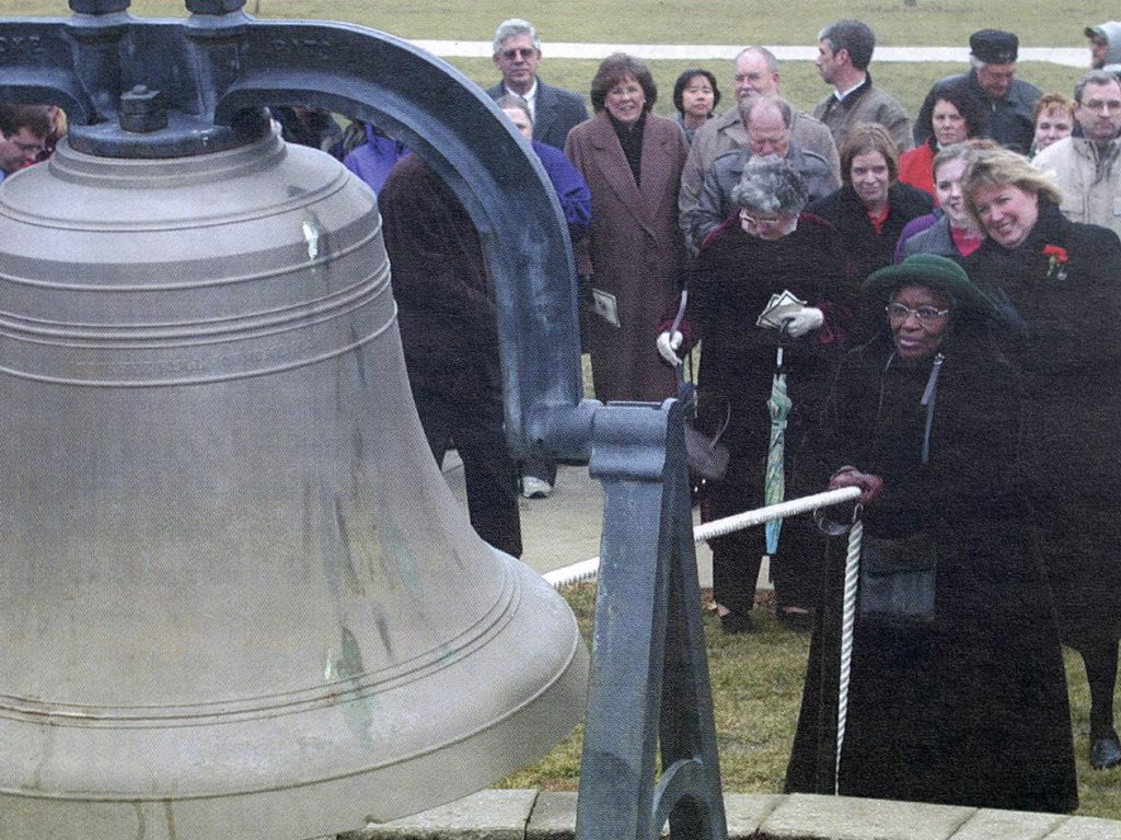 Dr. Mildred Pratt rings the Old Main Bell in front of a crowd on the Quad