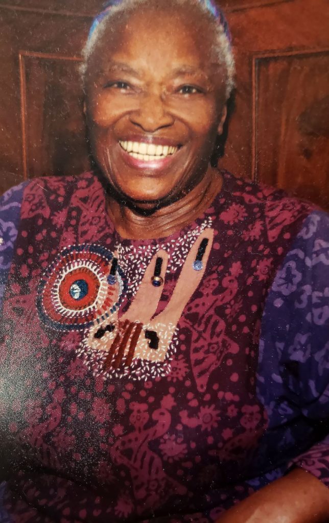 Dr. Mildred Pratt, smiling, wearing a red and purple top