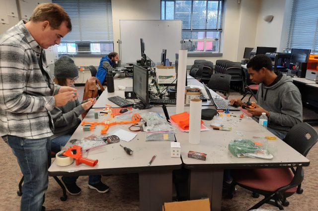 Students work together to build model rocket.